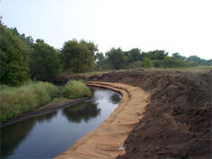 [Photo: Erosion blanket covering riverbank.]