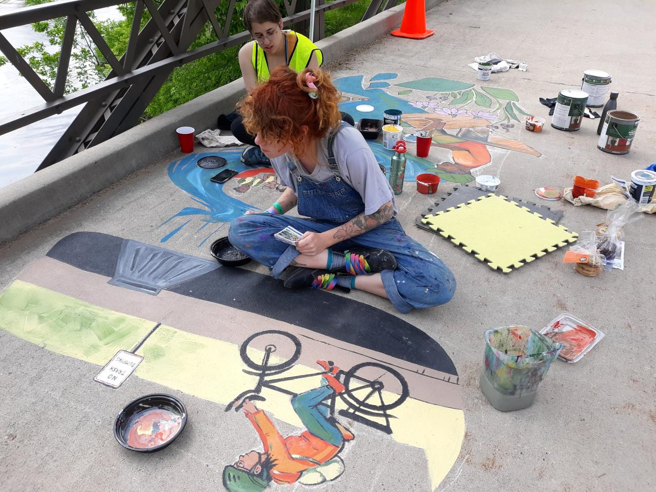 Artists painting of the stormwater mural Artists work on the 2019 stormwater mural at Lake Phalen